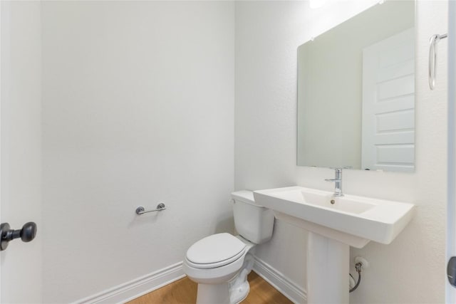 bathroom featuring hardwood / wood-style flooring and toilet