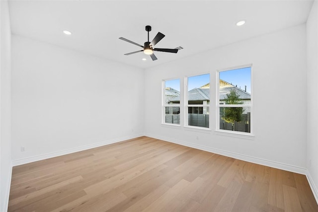 empty room with ceiling fan and light hardwood / wood-style flooring