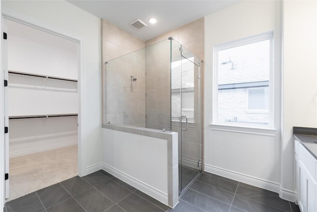 bathroom featuring tile patterned floors, vanity, and a shower with shower door