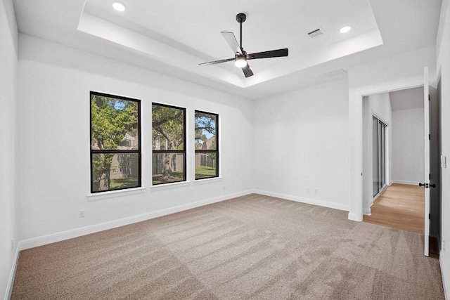 1509 Jay Wolf, Georgetown, TX 78628 - spare room featuring a tray ceiling, carpet floors, a ceiling fan, baseboards, and recessed lighting