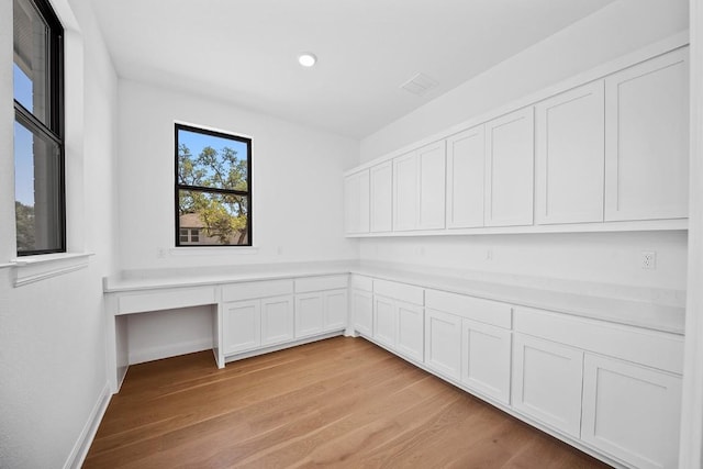 1509 Jay Wolf, Georgetown, TX 78628 - unfurnished office featuring light wood-type flooring, built in desk, recessed lighting, and baseboards