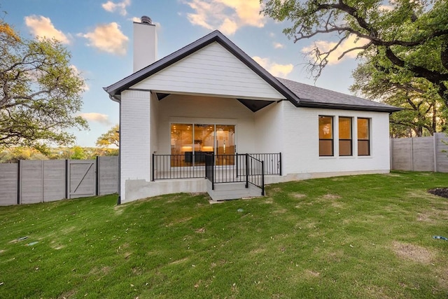 1509 Jay Wolf, Georgetown, TX 78628 - back of house at dusk featuring a chimney and brick siding