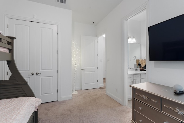 bedroom with light colored carpet, connected bathroom, and a closet