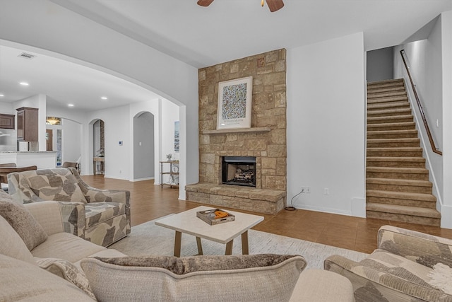 living room with ceiling fan, light wood-type flooring, and a fireplace