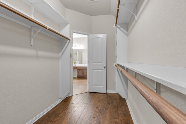 walk in closet featuring dark hardwood / wood-style flooring and lofted ceiling