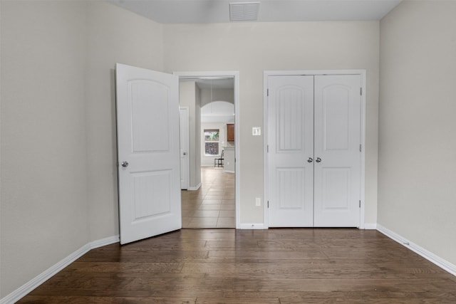 unfurnished bedroom featuring dark hardwood / wood-style floors and a closet