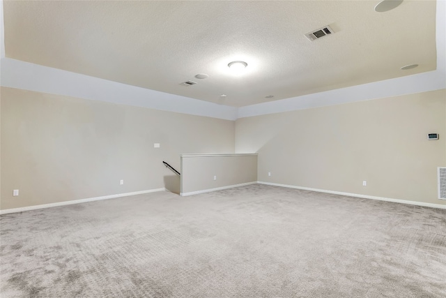 spare room featuring carpet floors and a textured ceiling