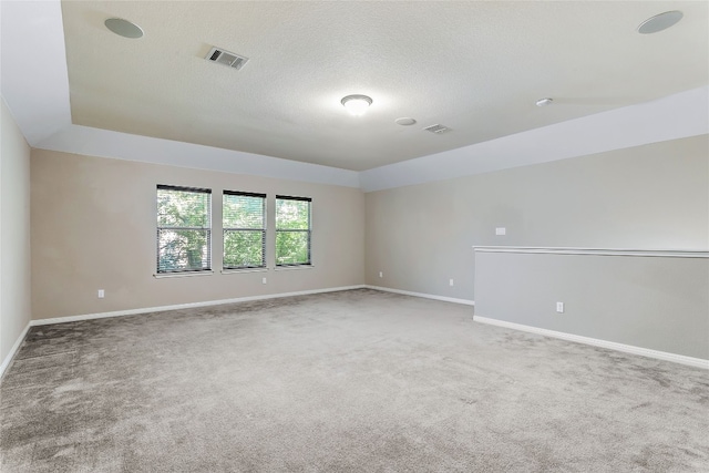 carpeted spare room featuring a textured ceiling