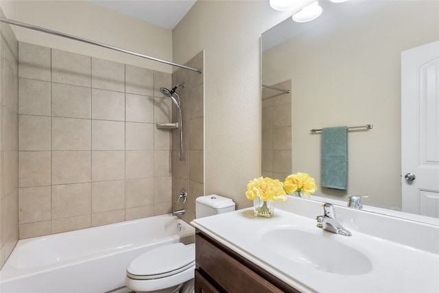 full bathroom with vanity, tiled shower / bath, and toilet