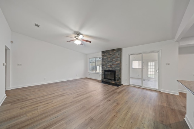 unfurnished living room with plenty of natural light, ceiling fan, light wood-type flooring, and a fireplace