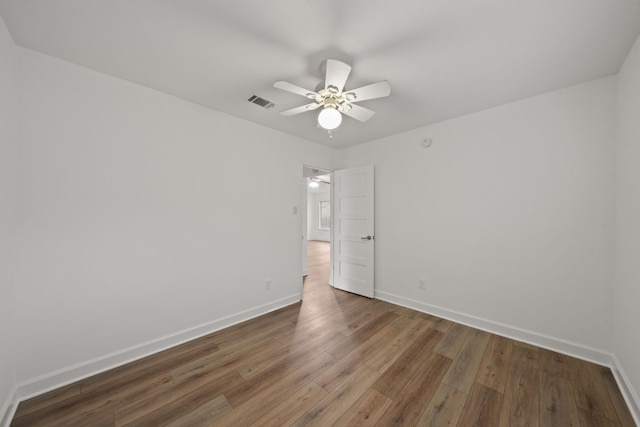 unfurnished room with ceiling fan and dark wood-type flooring