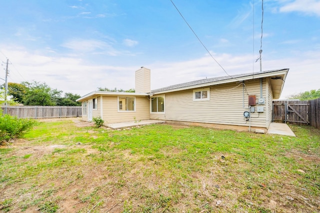 back of property with a patio area and a lawn