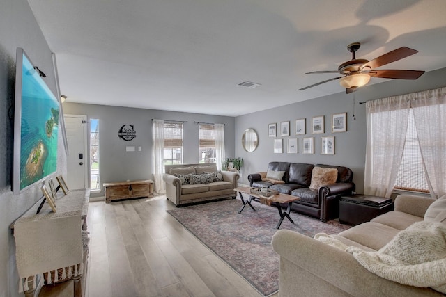 living room with light wood-type flooring and ceiling fan