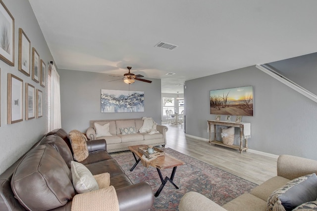 living room with ceiling fan and light hardwood / wood-style flooring