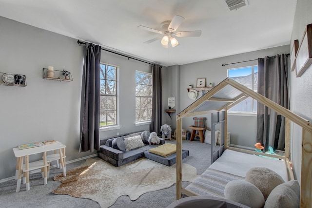 living area with carpet, plenty of natural light, and ceiling fan