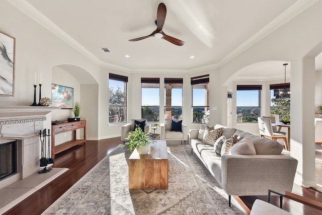 living room featuring dark hardwood / wood-style floors, a wealth of natural light, and ornamental molding