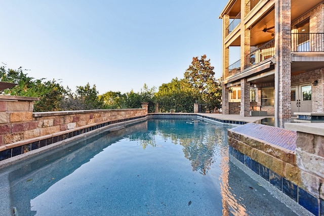 view of swimming pool featuring ceiling fan and a patio area