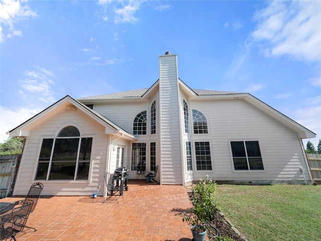 back of house featuring a patio area and a lawn