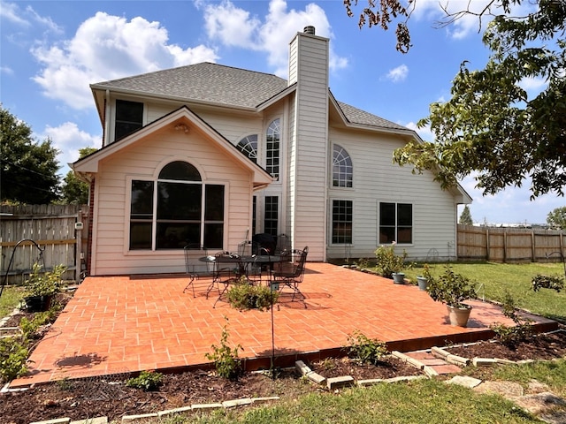 back of property featuring a lawn and a patio