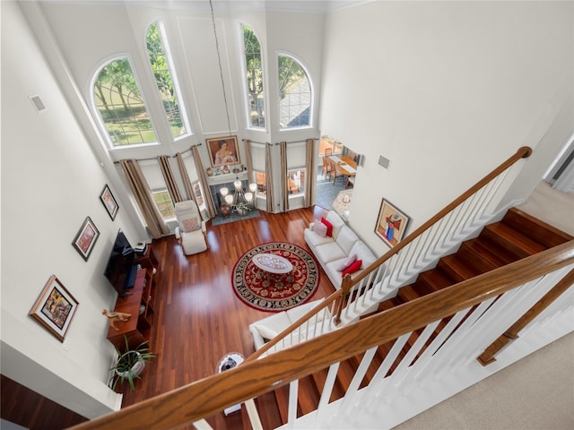 stairway featuring a high ceiling and wood-type flooring