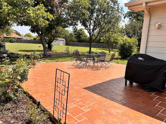 view of patio with a storage unit and grilling area