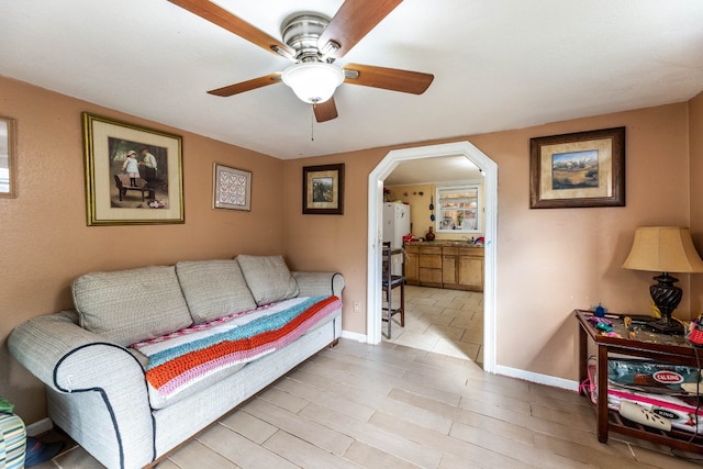 living room with ceiling fan and light hardwood / wood-style flooring