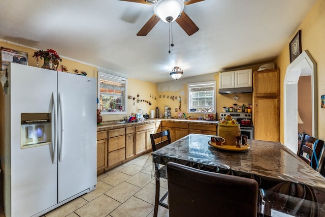 kitchen featuring a wealth of natural light, white fridge with ice dispenser, electric range, and light tile patterned floors