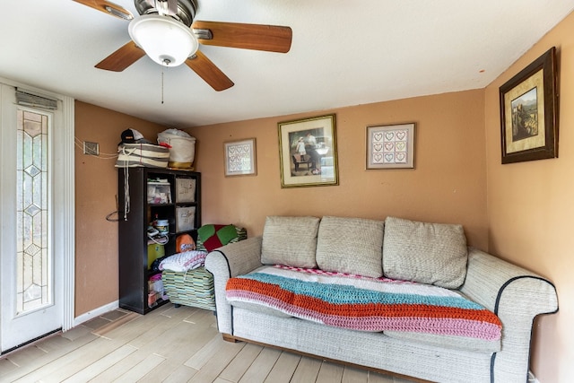 living room featuring ceiling fan, plenty of natural light, and light wood-type flooring