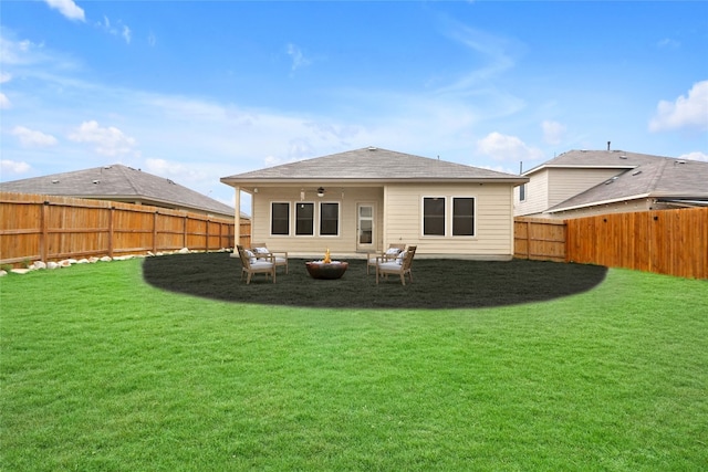 rear view of house featuring a lawn and ceiling fan