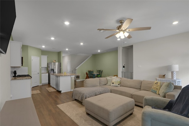 living room with ceiling fan and dark hardwood / wood-style flooring