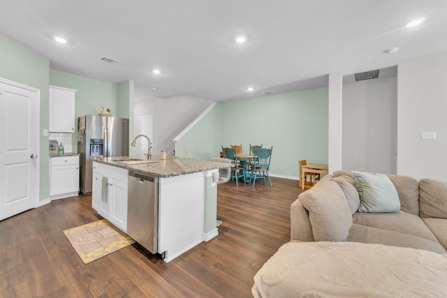 kitchen featuring white cabinets, appliances with stainless steel finishes, sink, and an island with sink