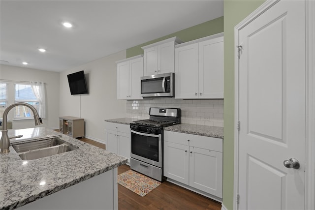 kitchen featuring sink, stainless steel appliances, dark hardwood / wood-style floors, backsplash, and white cabinets