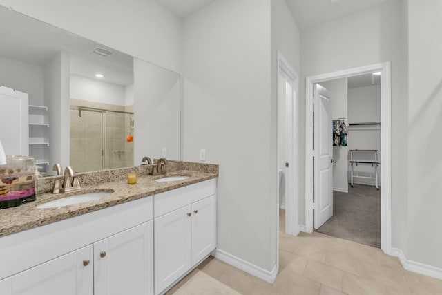 bathroom with tile patterned flooring, vanity, and walk in shower