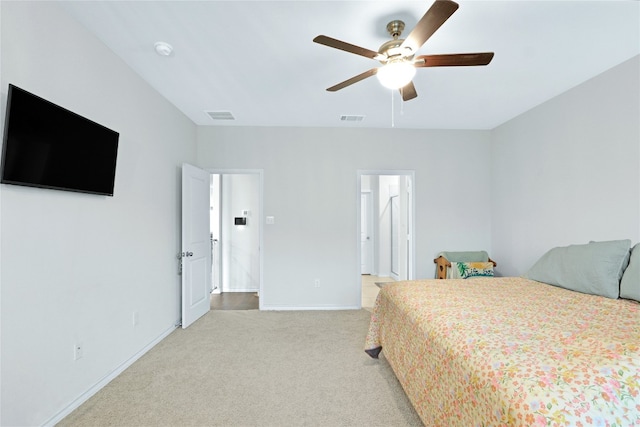 bedroom featuring connected bathroom, ceiling fan, and light carpet