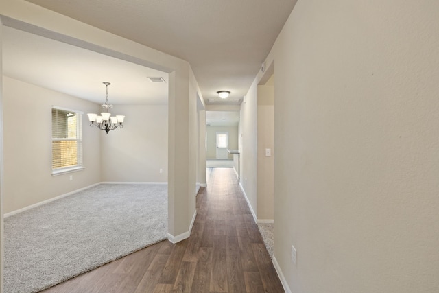 hall featuring dark hardwood / wood-style flooring and an inviting chandelier