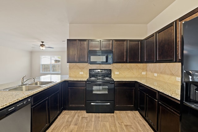 kitchen featuring black appliances, sink, ceiling fan, light stone countertops, and light wood-type flooring