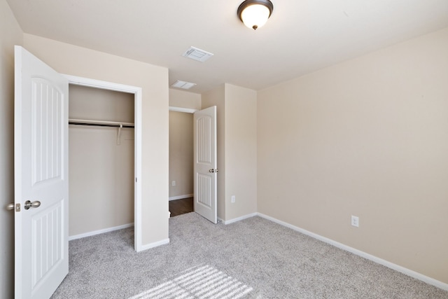 unfurnished bedroom featuring light carpet and a closet