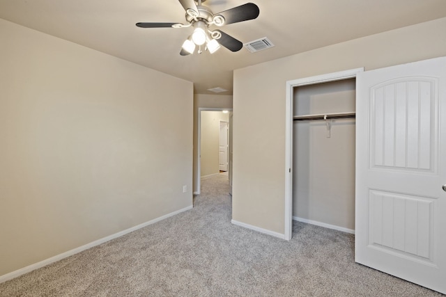 unfurnished bedroom featuring ceiling fan, a closet, and light colored carpet