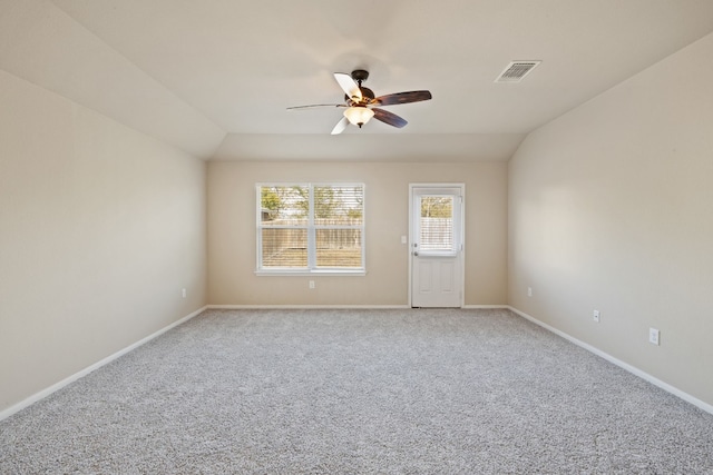 spare room featuring ceiling fan, light colored carpet, and vaulted ceiling