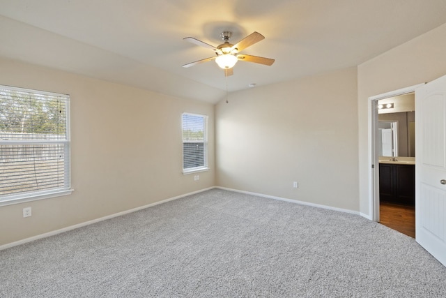 empty room featuring carpet flooring, ceiling fan, a healthy amount of sunlight, and lofted ceiling