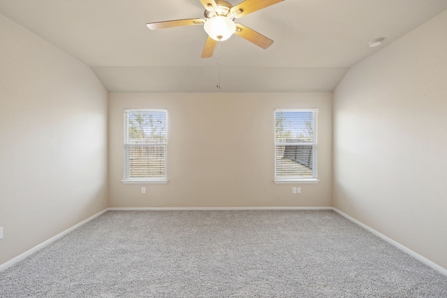 unfurnished room featuring carpet flooring, vaulted ceiling, a wealth of natural light, and ceiling fan