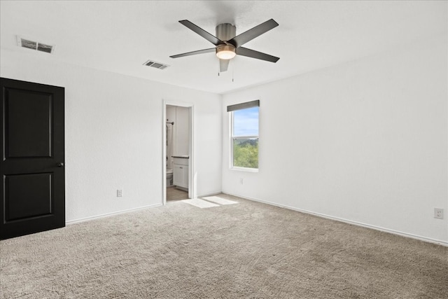 unfurnished bedroom with connected bathroom, carpet floors, and ceiling fan