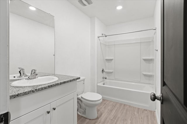 full bathroom featuring hardwood / wood-style floors, vanity,  shower combination, and toilet