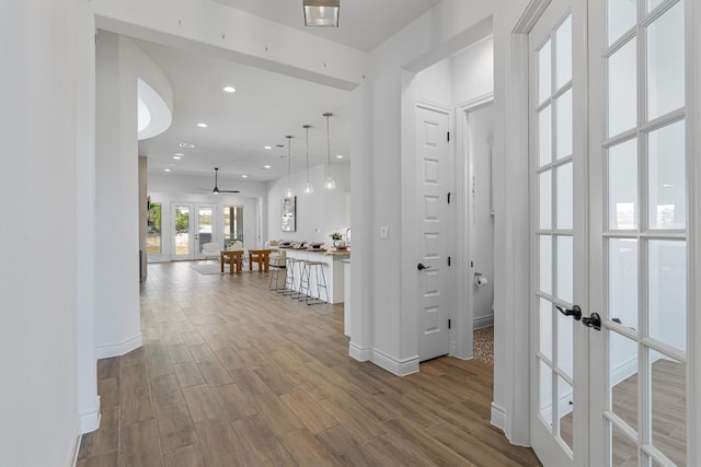 hall featuring french doors and light wood-type flooring