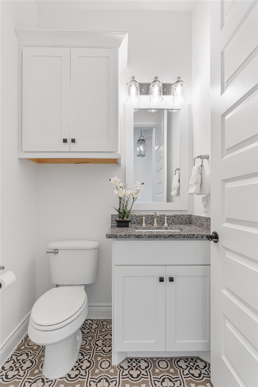 bathroom with tile patterned flooring, vanity, and toilet