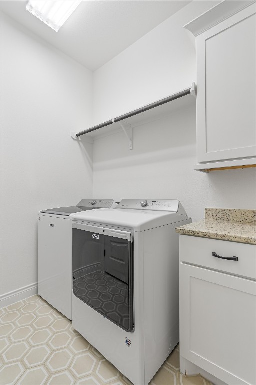 laundry room featuring cabinets and washer and dryer