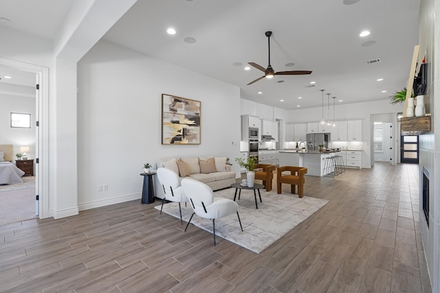 living room featuring light hardwood / wood-style floors and ceiling fan