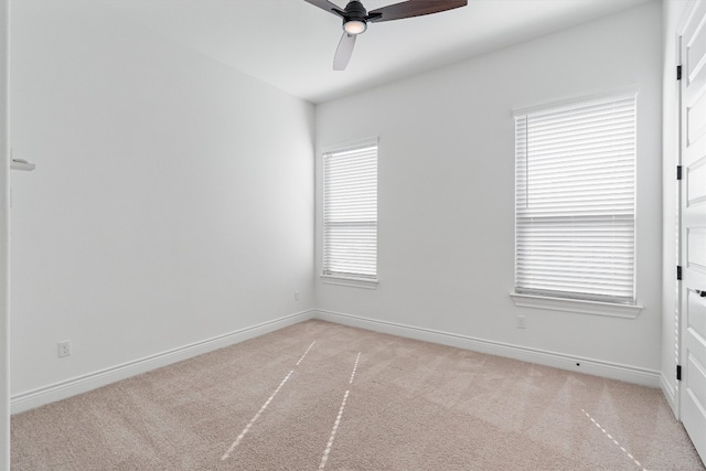 unfurnished room with ceiling fan, light carpet, and a wealth of natural light