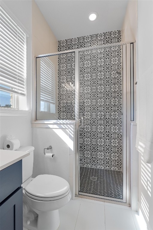 bathroom with tile patterned flooring, vanity, toilet, and walk in shower