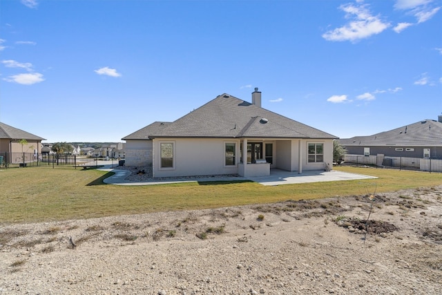 back of house with a lawn and a patio area